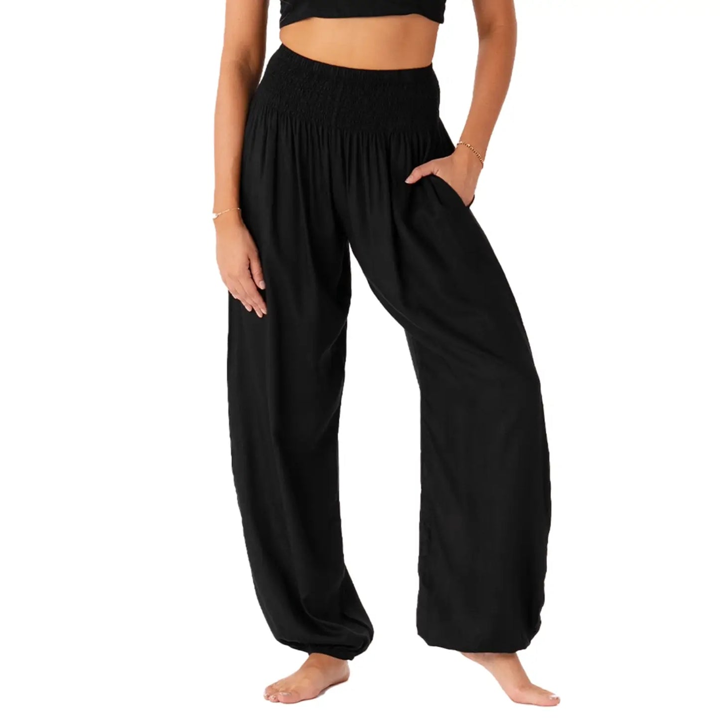 Person wearing black wide-leg harem pants on a white background