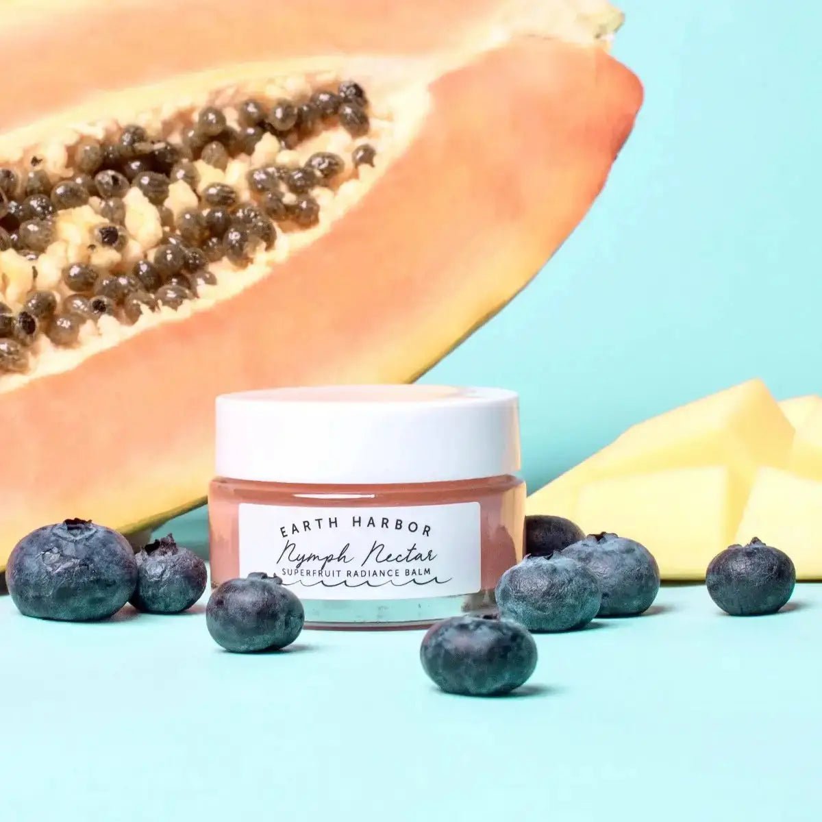 a blueberry and papaya face mask next to a half of a papaya