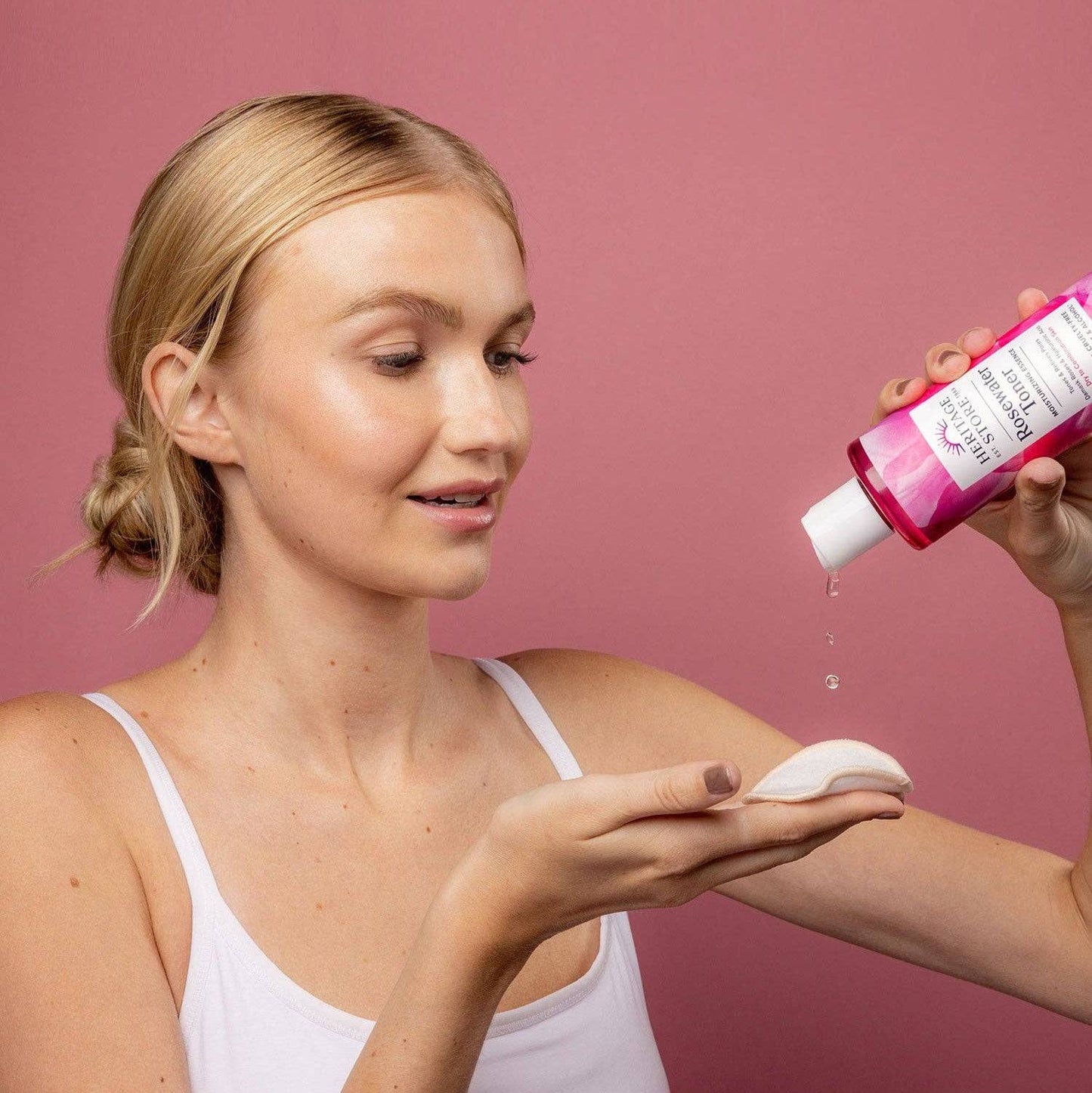 Woman applying Heritage Store Rosewater Toner Mini to cotton pad for glowing skin. Buy Rosewater Toner for Glowing Skin | Shop Now.