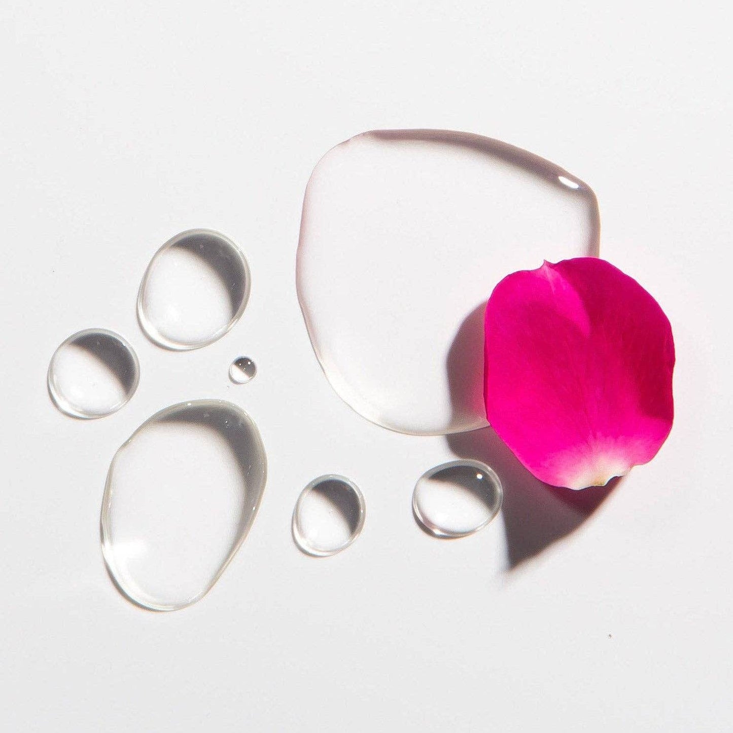 Heritage Store Rosewater Toner Mini with water droplets and pink rose petal, ideal for hydrating and refreshing skin naturally.