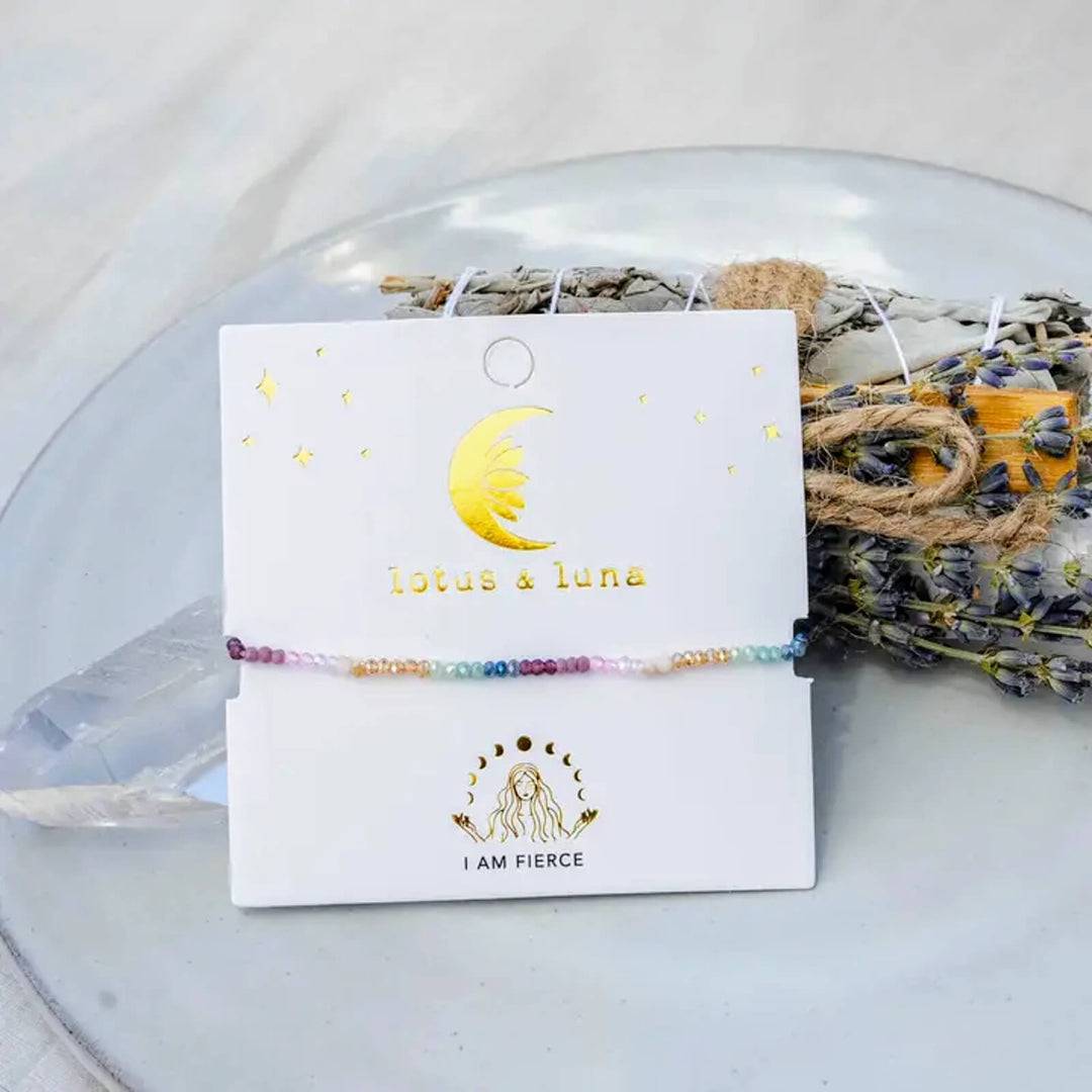 adjustable affirmation bracelet next to a quartz crystal and dried flowers