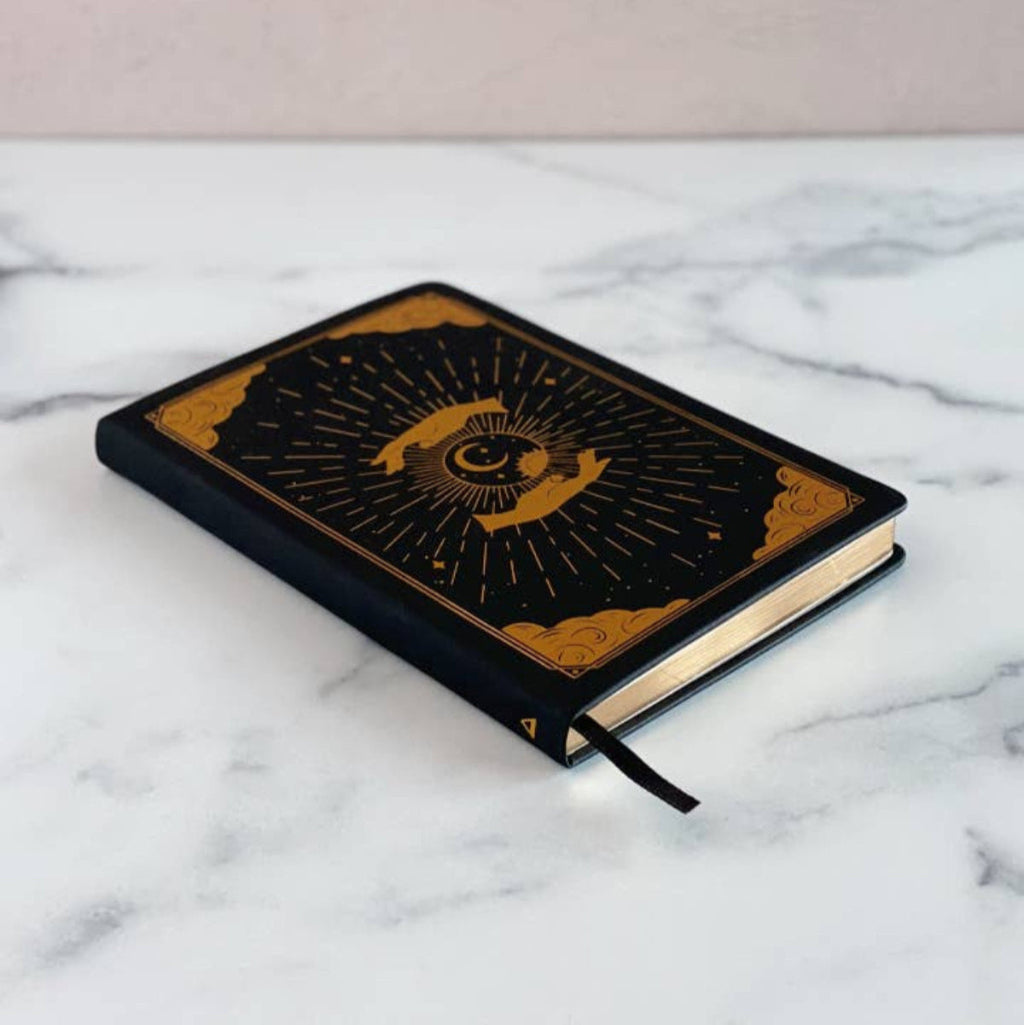 Black intention and mindfulness notebook with gold design on a marble surface