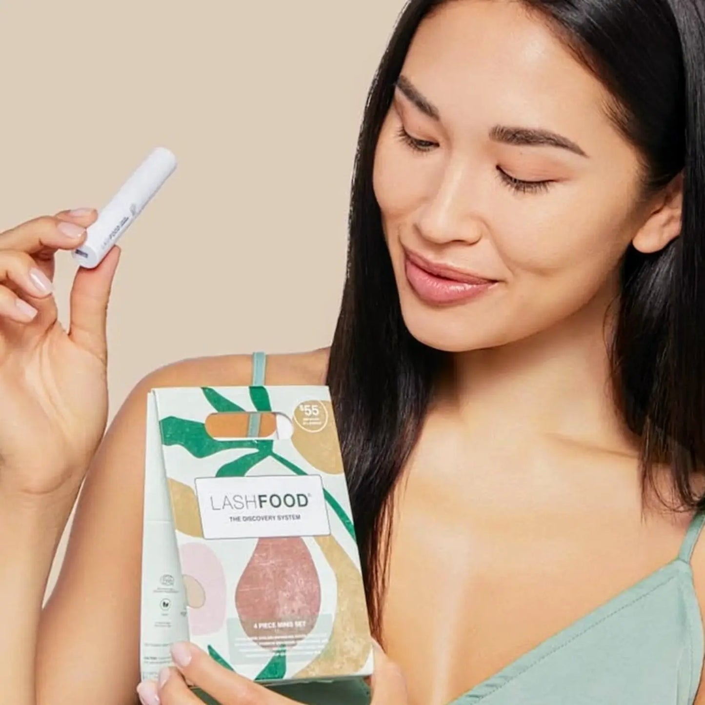 a woman holding the Lashfood Discovery System 4 Piece Minis Set by Lashfood with eyebrow and eyelash growth serum