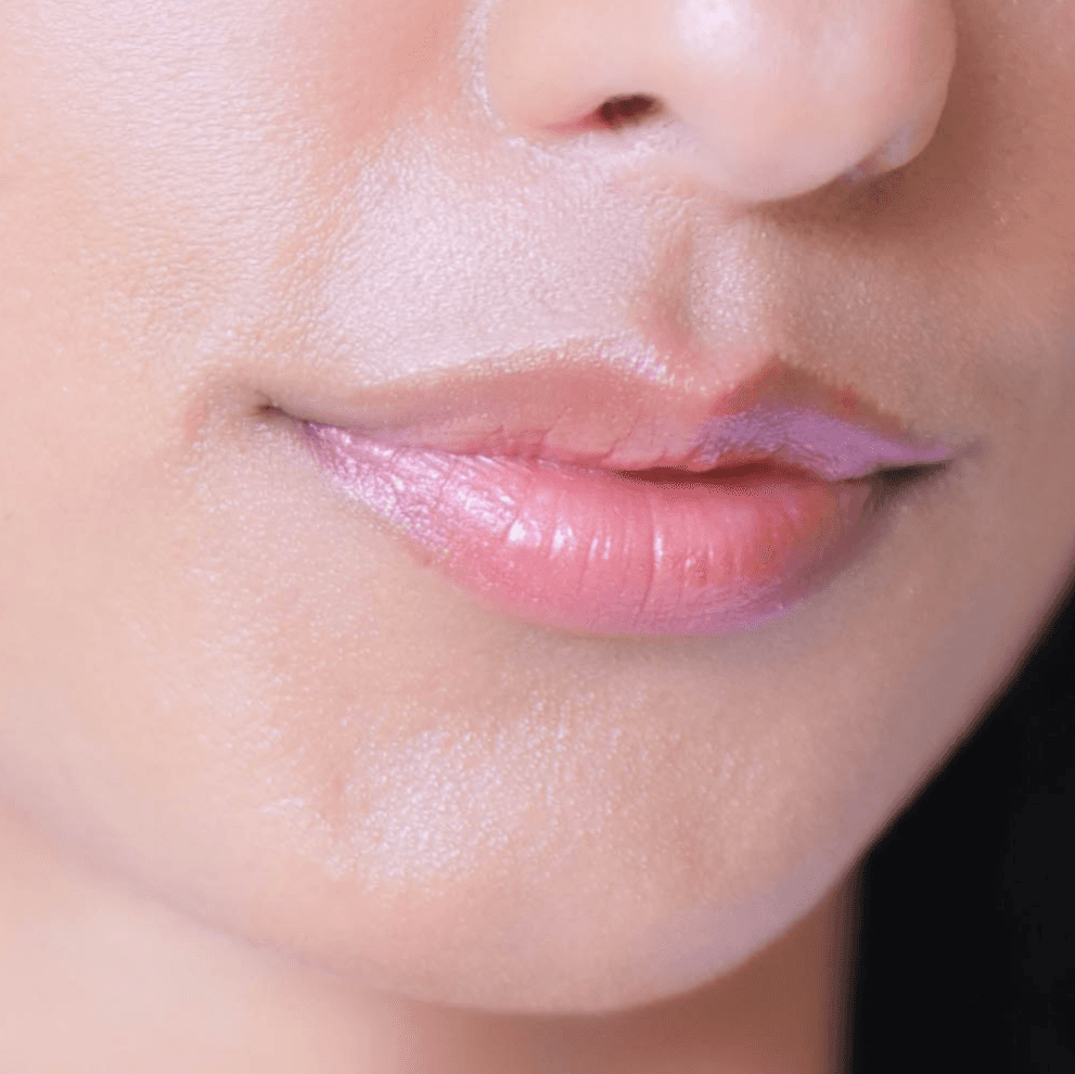 Close-up of lips wearing Organic Nude Lip Balm - Vegan Hydration, showing a natural tinted finish and smooth, moisturized texture.