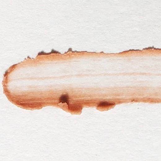 Swatch of Organic Nude Lip Balm - Vegan Hydration showing smooth, tinted nude color with creamy texture on white background.