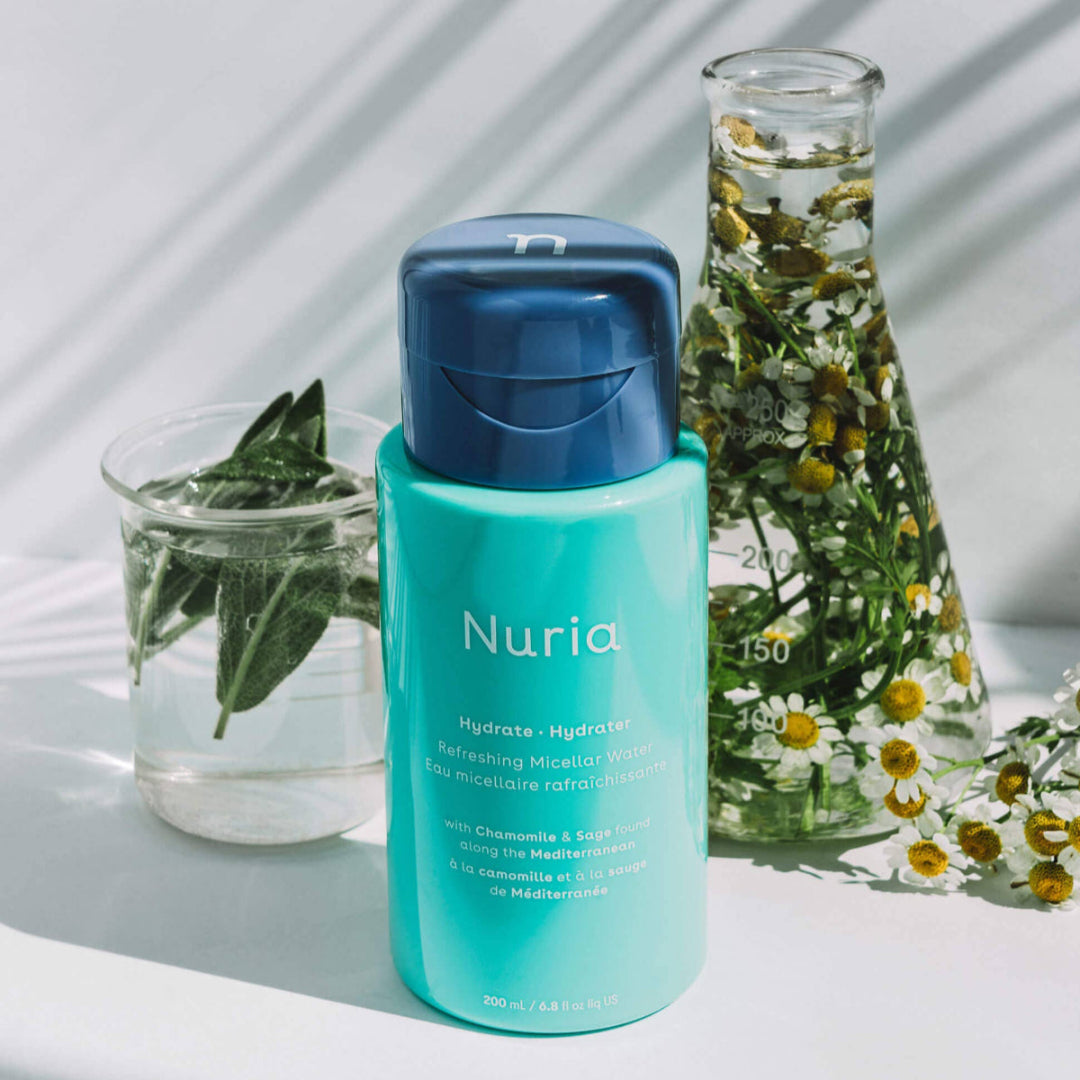 Nuria skincare bottle with natural elements on a light background