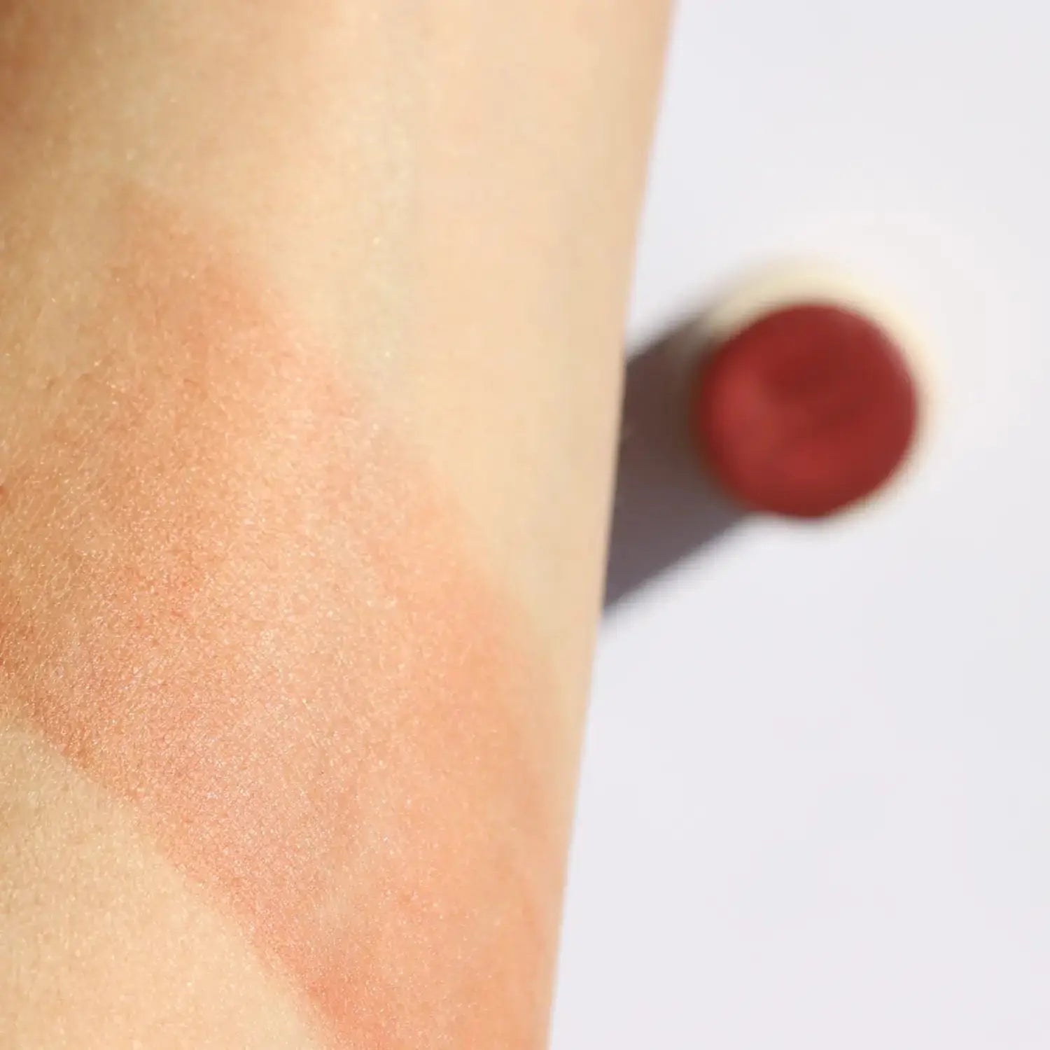 Swatch of Pinch Pink Organic Blush Stick on skin showing its creamy texture and soft pink hue. Ideal for a natural, dewy finish on all skin types.