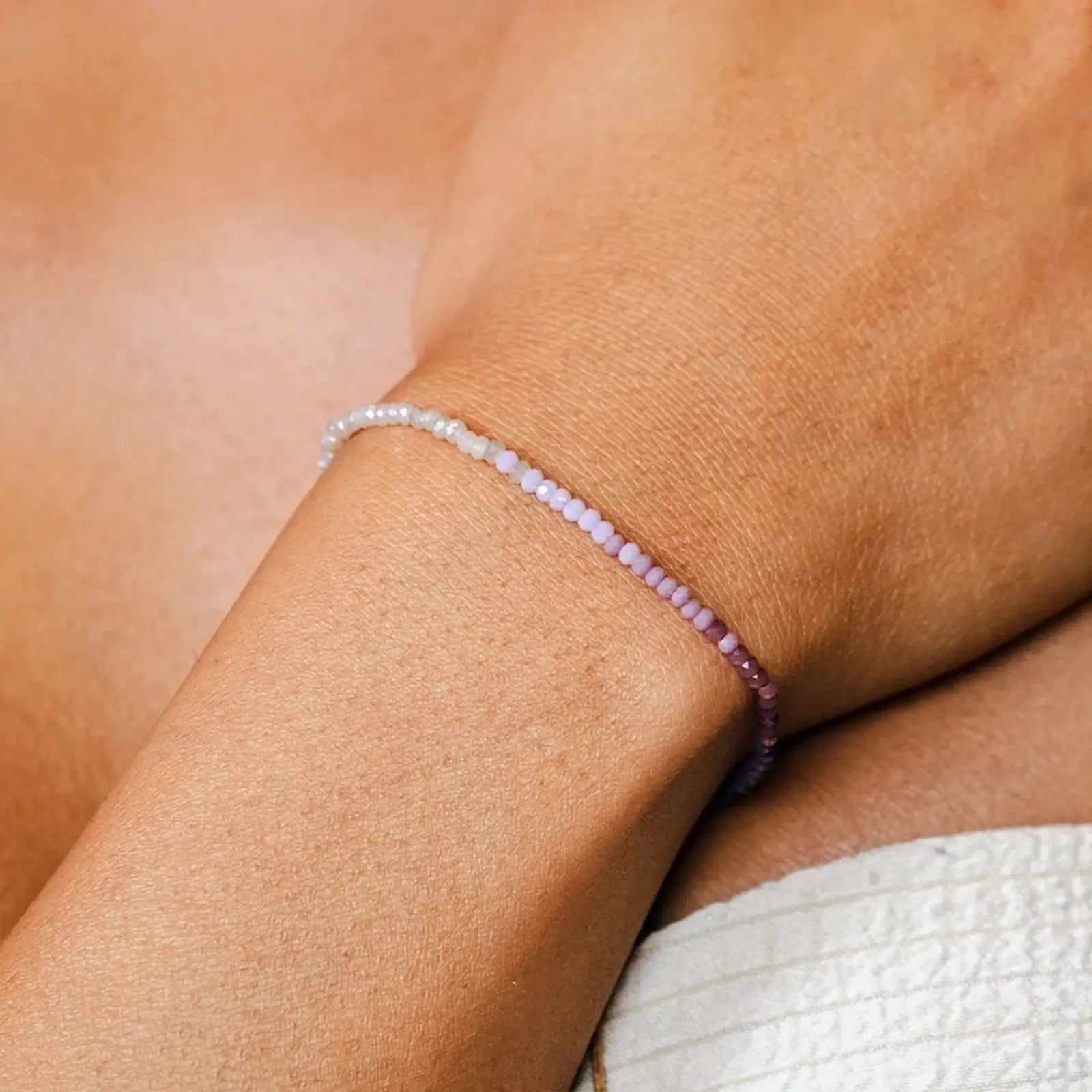 Stay Wild Moon Child Boho Bead Bracelet with pink, purple and white shimmery beads on a wrist