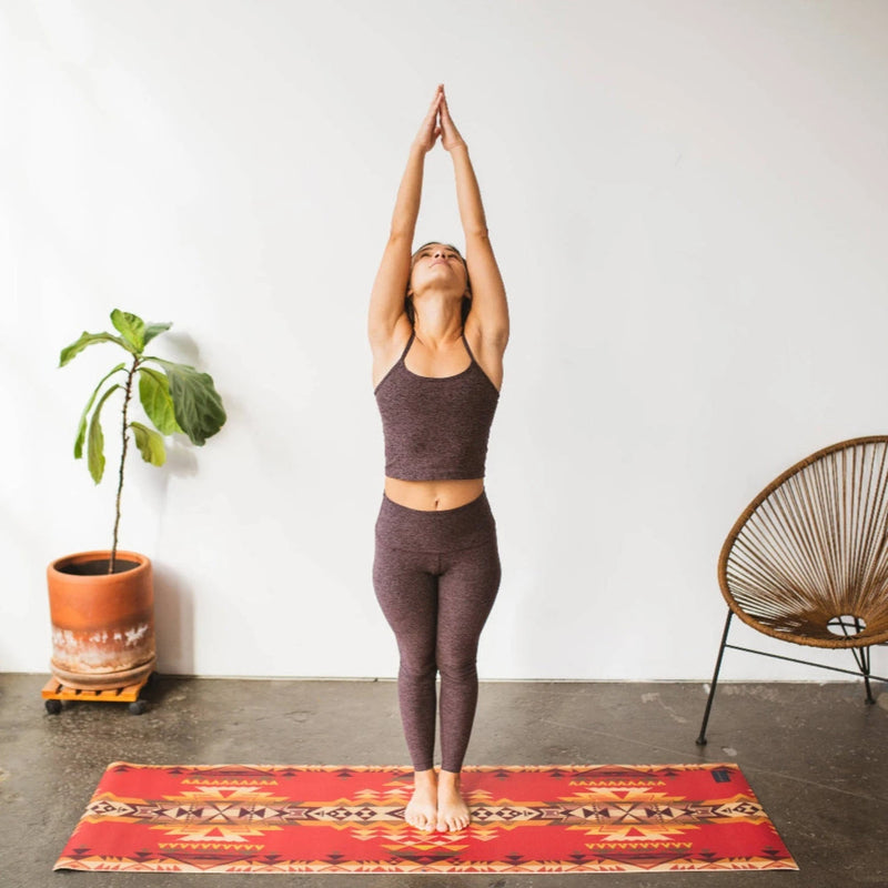 a person in a standing asana on a yune yoga mat with Pendleton highland peak design on it