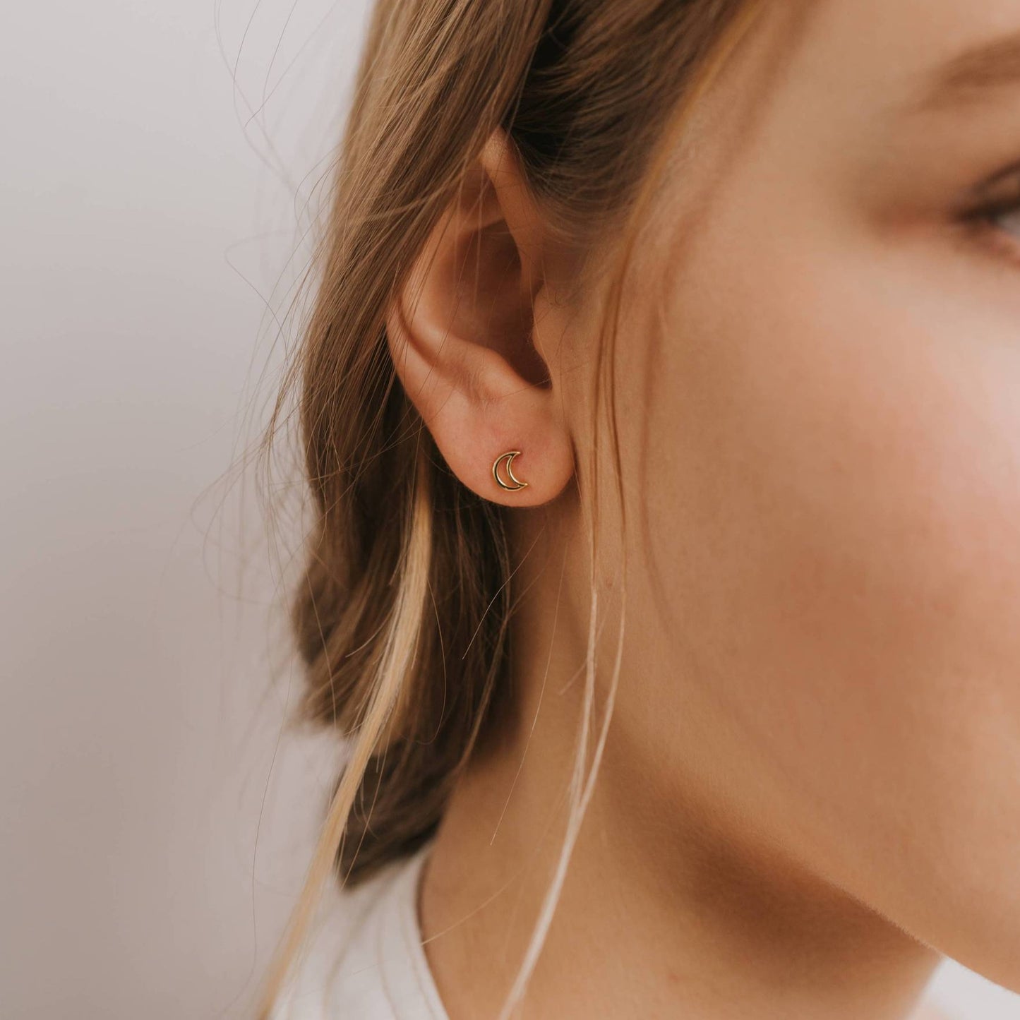 model wearing gold moon stud earrings 