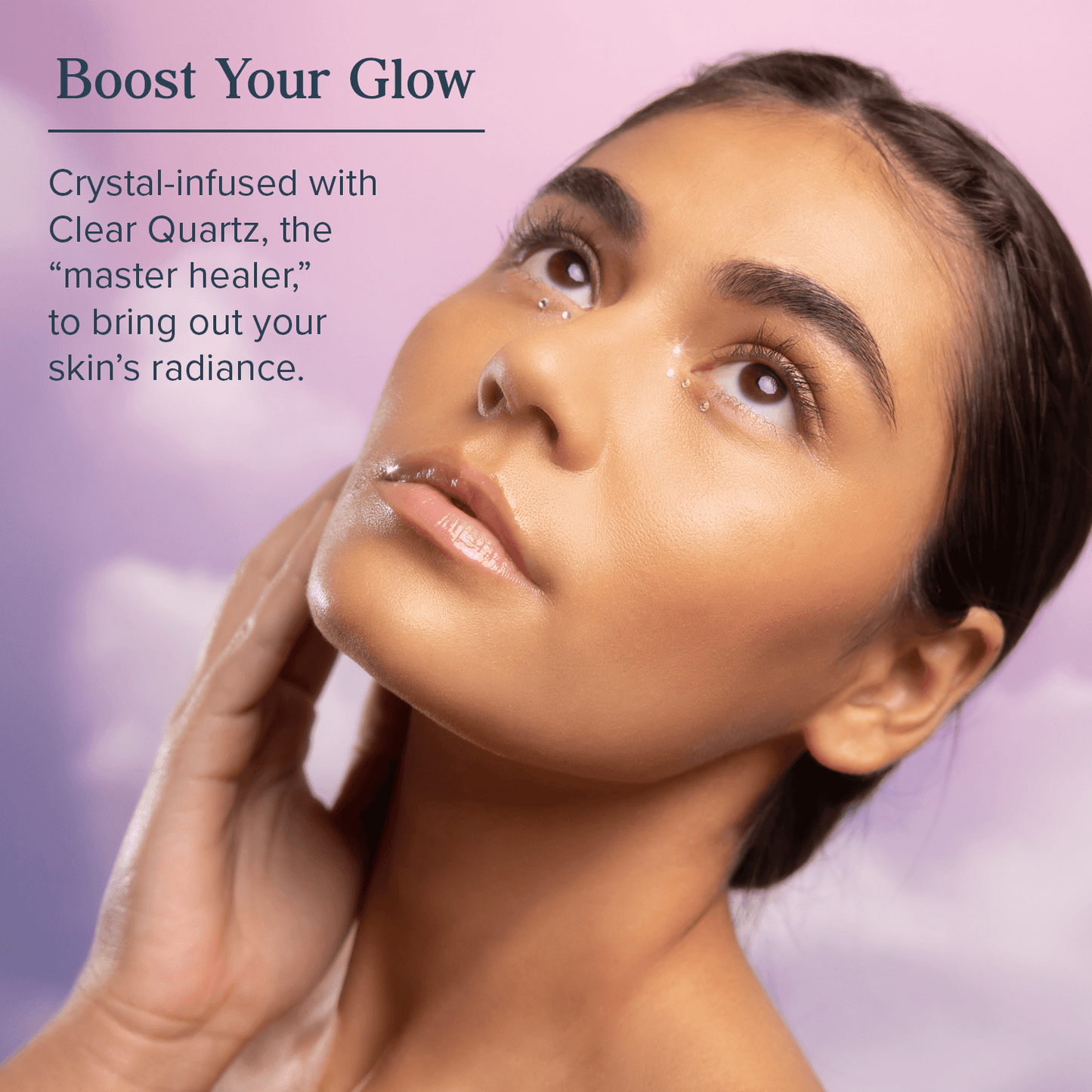 Model applying Aura Glow Eye Cream infused with Clear Quartz to enhance skin radiance and brightness around the eyes.