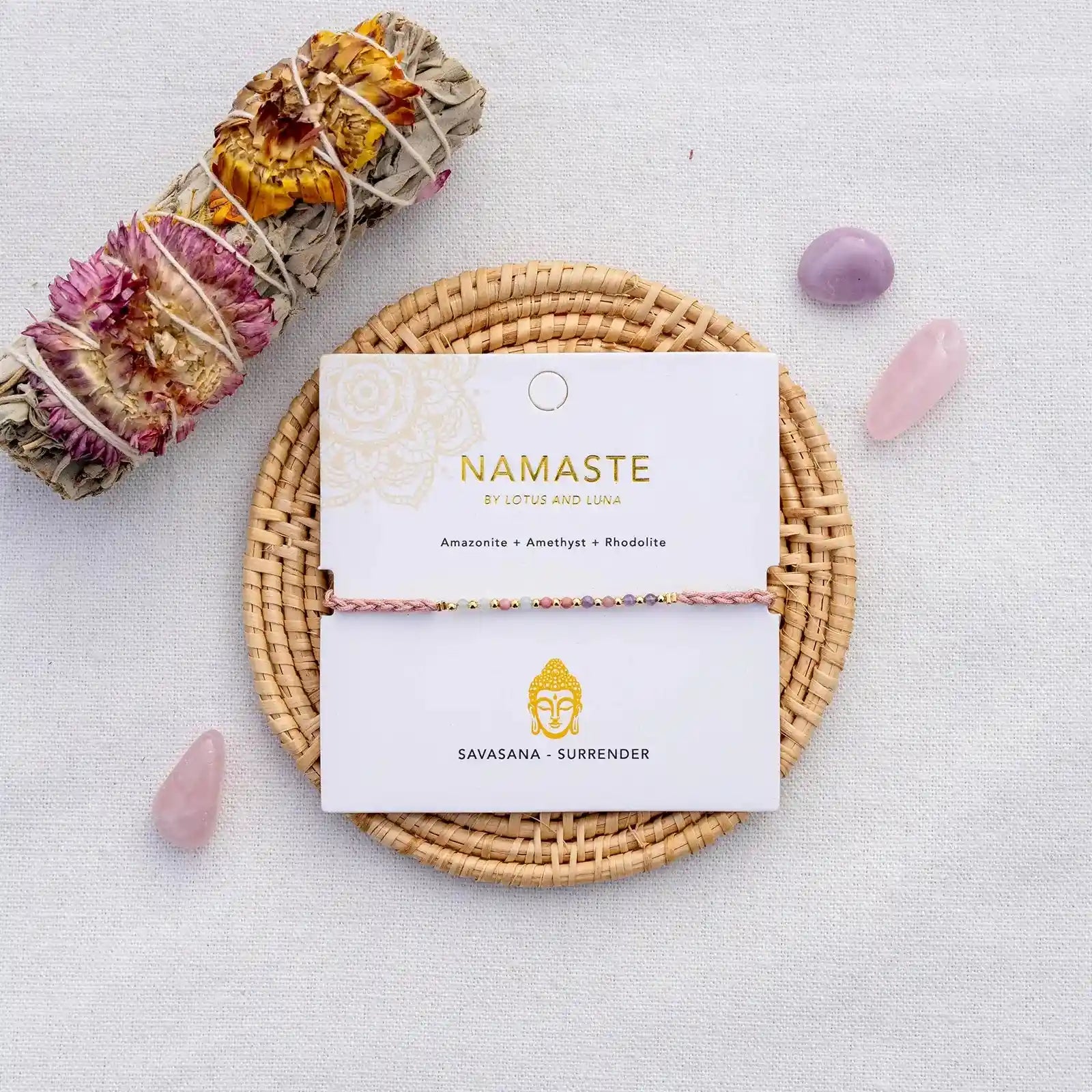 Savasana Namaste Yoga Bracelet on Jewelry Card with Buddha Illustration surrounded by raw gemstones and a sage stick.