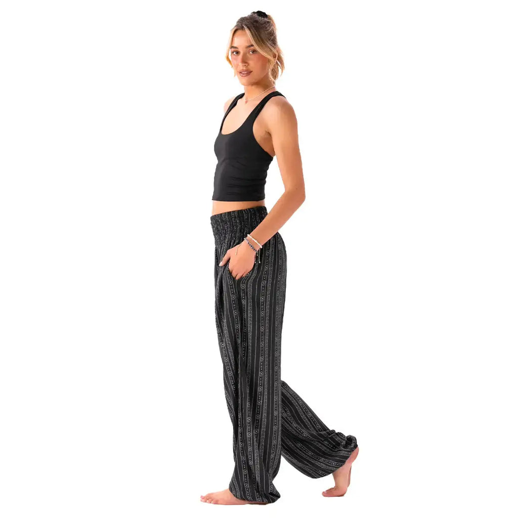 Side view of Striped Black Boho Harem Pants with Pockets by Lotus and Luna, showcasing the flowy silhouette and casual fit.