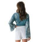Back view of Sapphire Beach Daydreamer Bell Sleeve Top with white mandala print and flared sleeves, paired with white shorts.