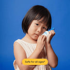 Young girl holding Magic Molecule Hypochlorous Acid Spray Mini against blue background. Gentle skin care safe for all ages