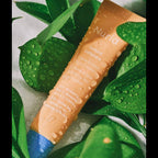 Nuria Beauty Eye Cream tube laying on fresh green leaves with water droplets, highlighting natural ingredients of Mulberry.