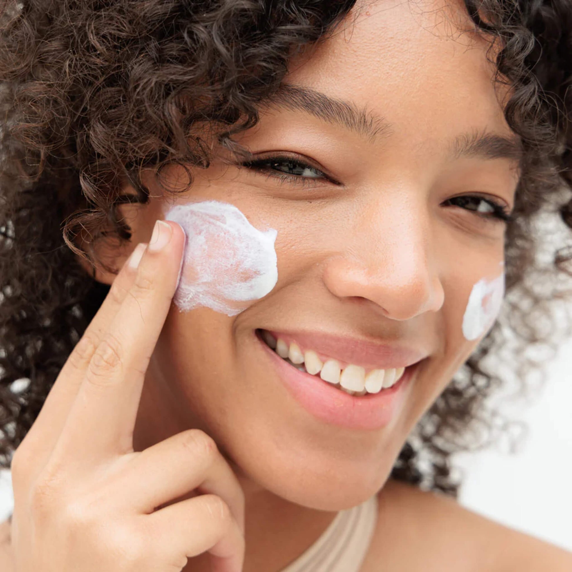 woman putting on Sunbaked SPF on her face