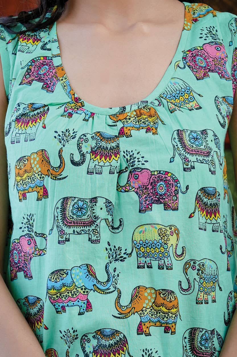 a woman wearing a green top with elephants on it