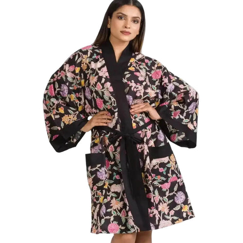 Woman wearing a black floral kimono-style robe on a white background