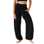 Person wearing black wide-leg harem pants on a white background