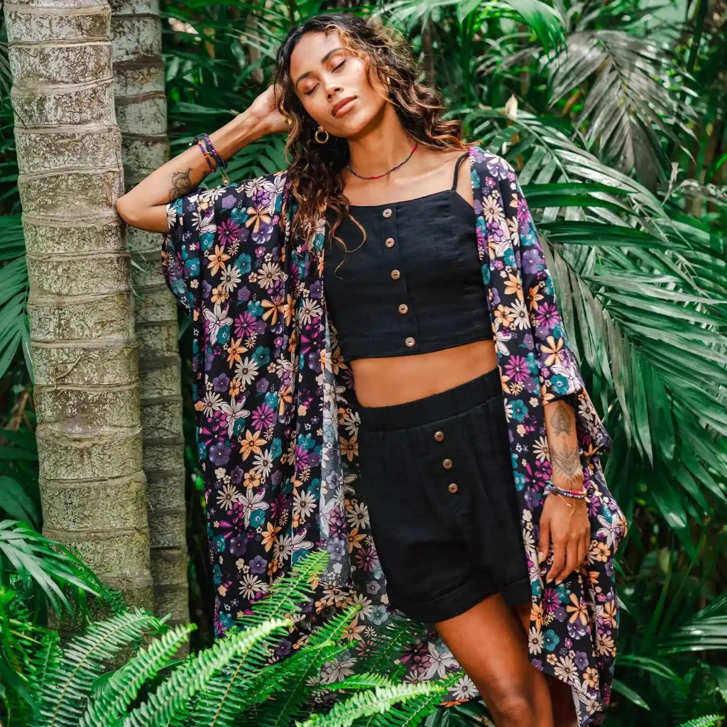 Lotus and Luna Pattaya Kimono on model next to a palm tree