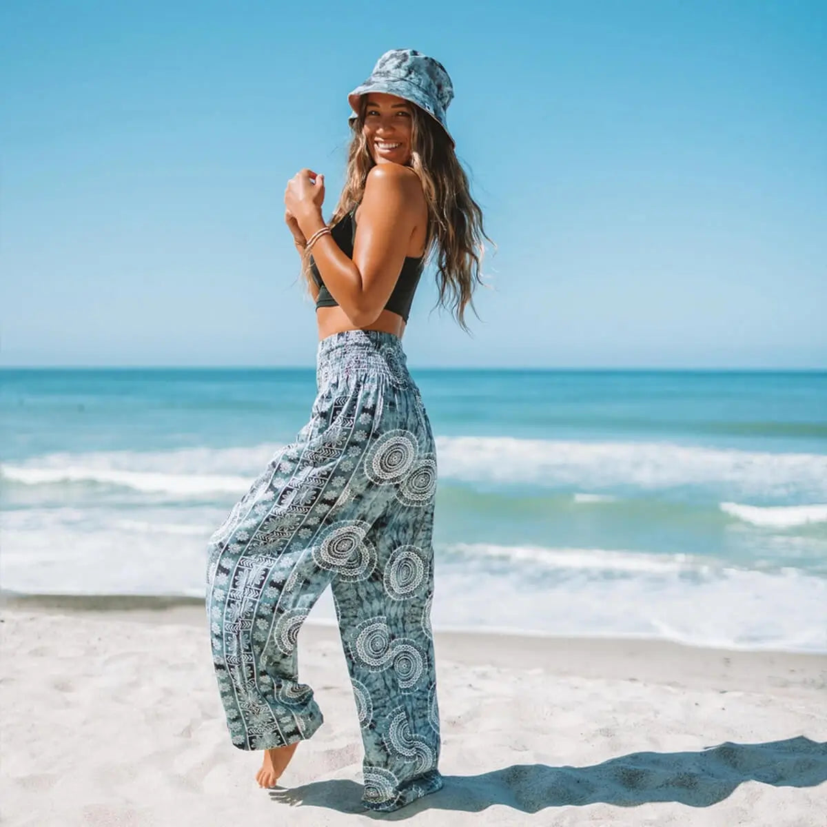 woman wearing boho harem pants on the beach with matching hat