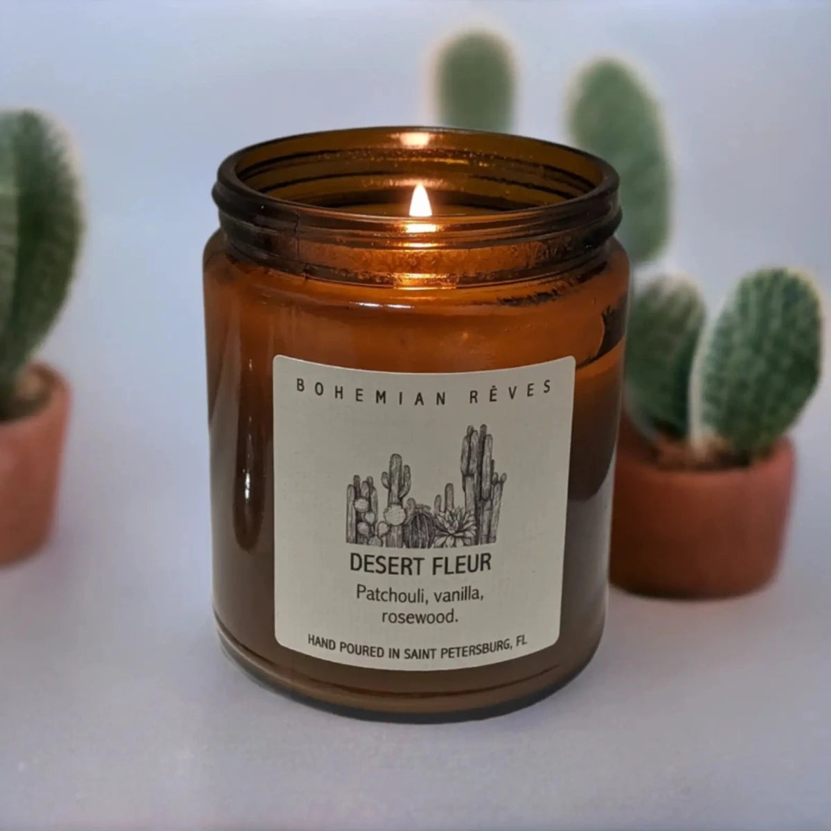 Bohemian Rêves Desert Fleur Perfume Candle next to cactus plants