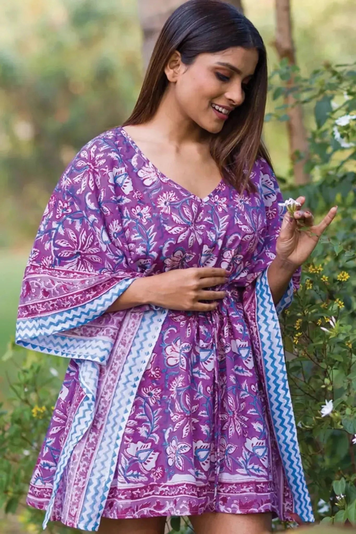 a women outside wearing a floral print short caftan dress
