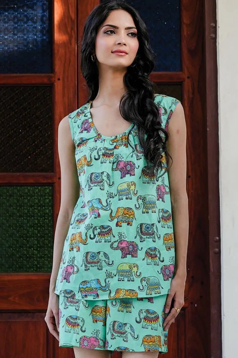 a woman in a short pajama set standing in front of a wooden door