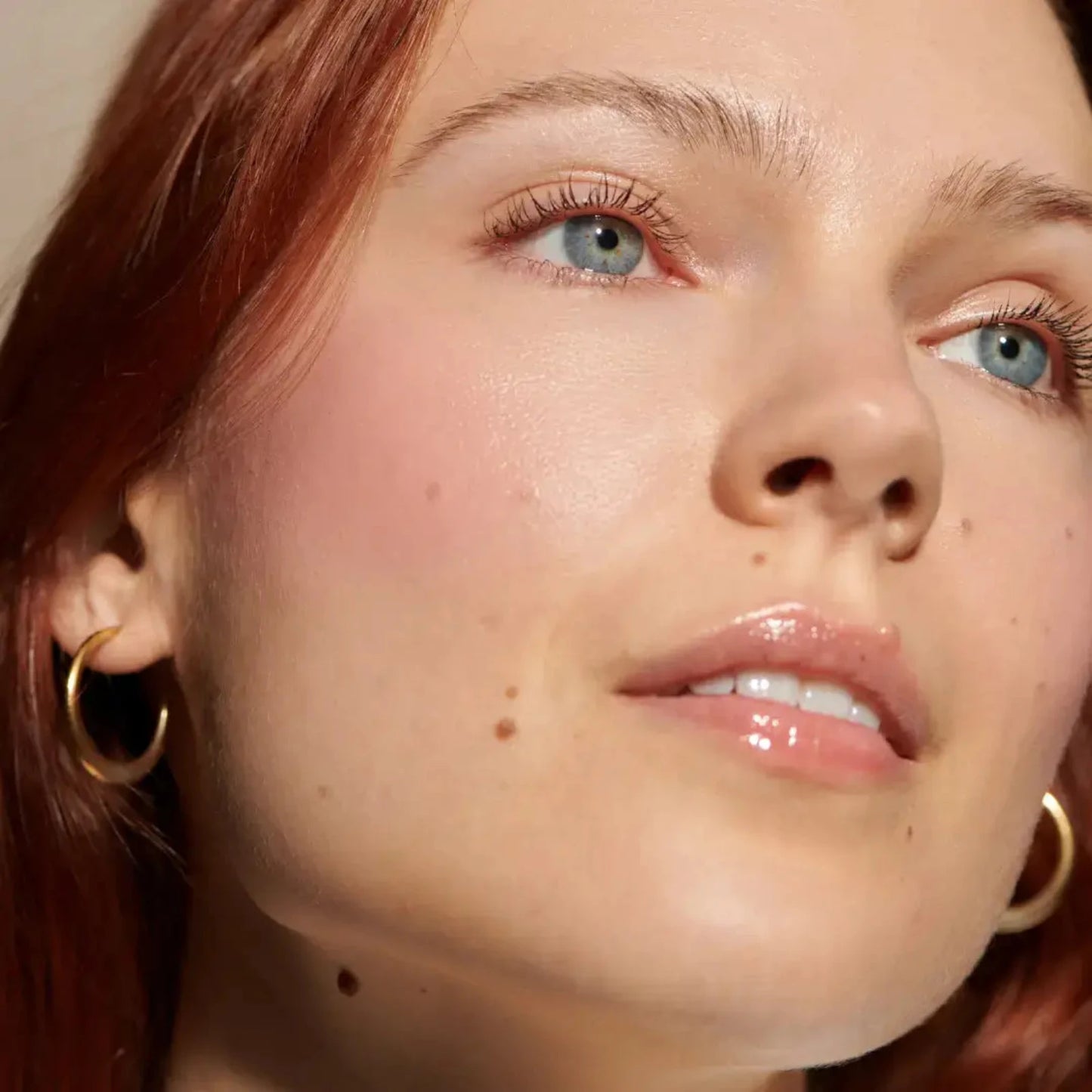 a woman with light skin wearing minori cream blush in sweet pea pink on her cheeks