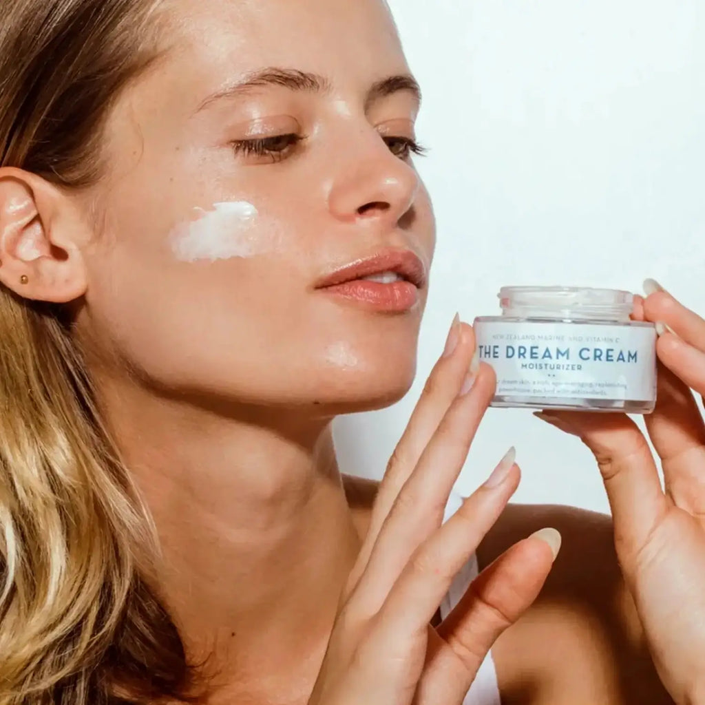 A woman applying Organic Skin Co Dream Cream to her cheek