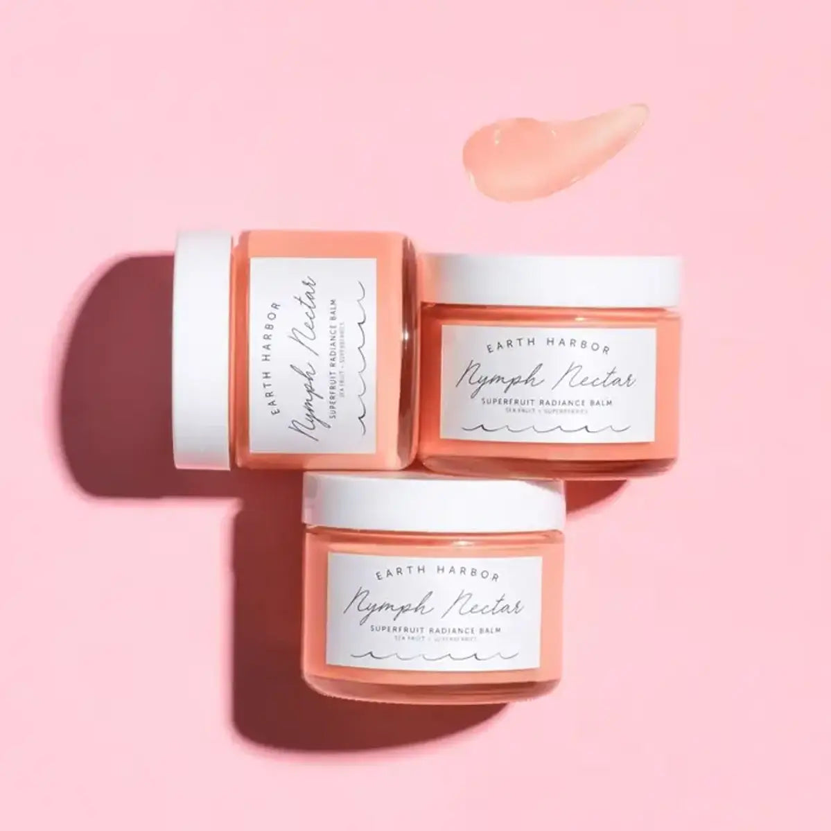 three jars of face balm on a pink background