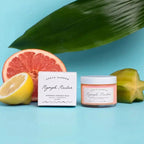 a grapefruit and fruit extract facial balm next to a grapefruit and a lemon