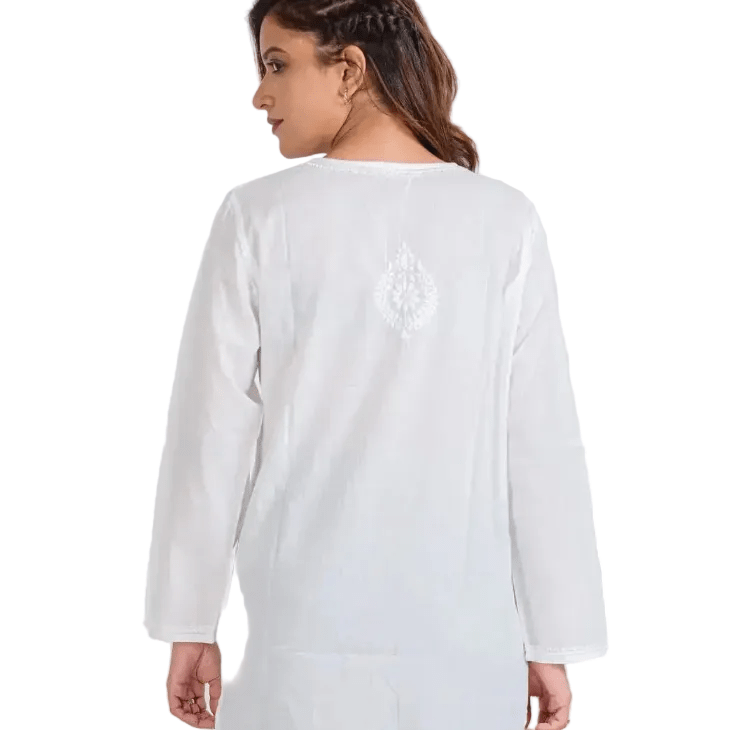 A woman shown from the back wearing a white long-sleeve tunic with a small white embroidered motif centered on the upper back