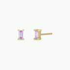 Gold stud earrings with pastel purple baguette stones on a white background