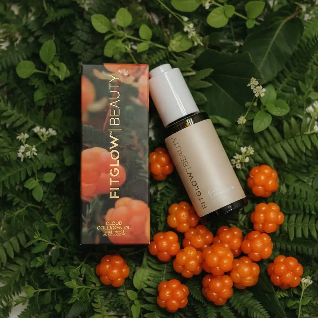 FitGlow Beauty Cloud Collagen Oil bottle and its matching box, styled on a bed of green leaves and orange cloud berries.