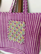 Reversible quilted cotton floral market bag with large front pocket.