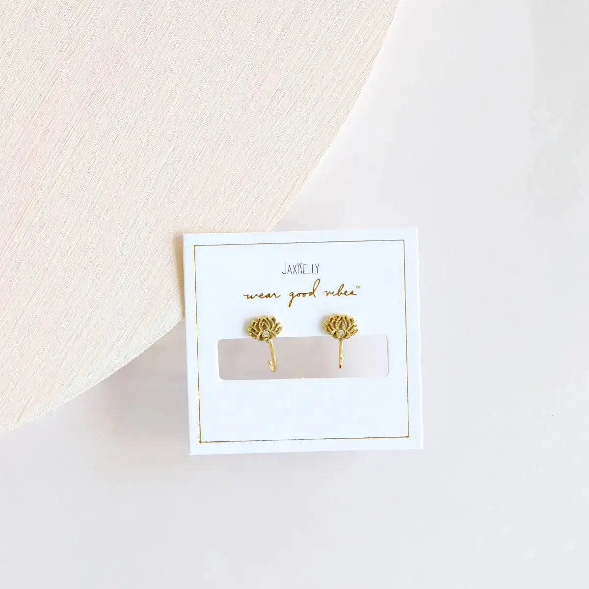 a pair of lotus earrings sitting on a table