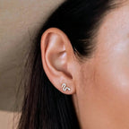 a close up of a woman wearing gold snake earrings for pierced ears
