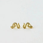 a pair of gold pave stud snake earrings with white cubic zirconia accent stones