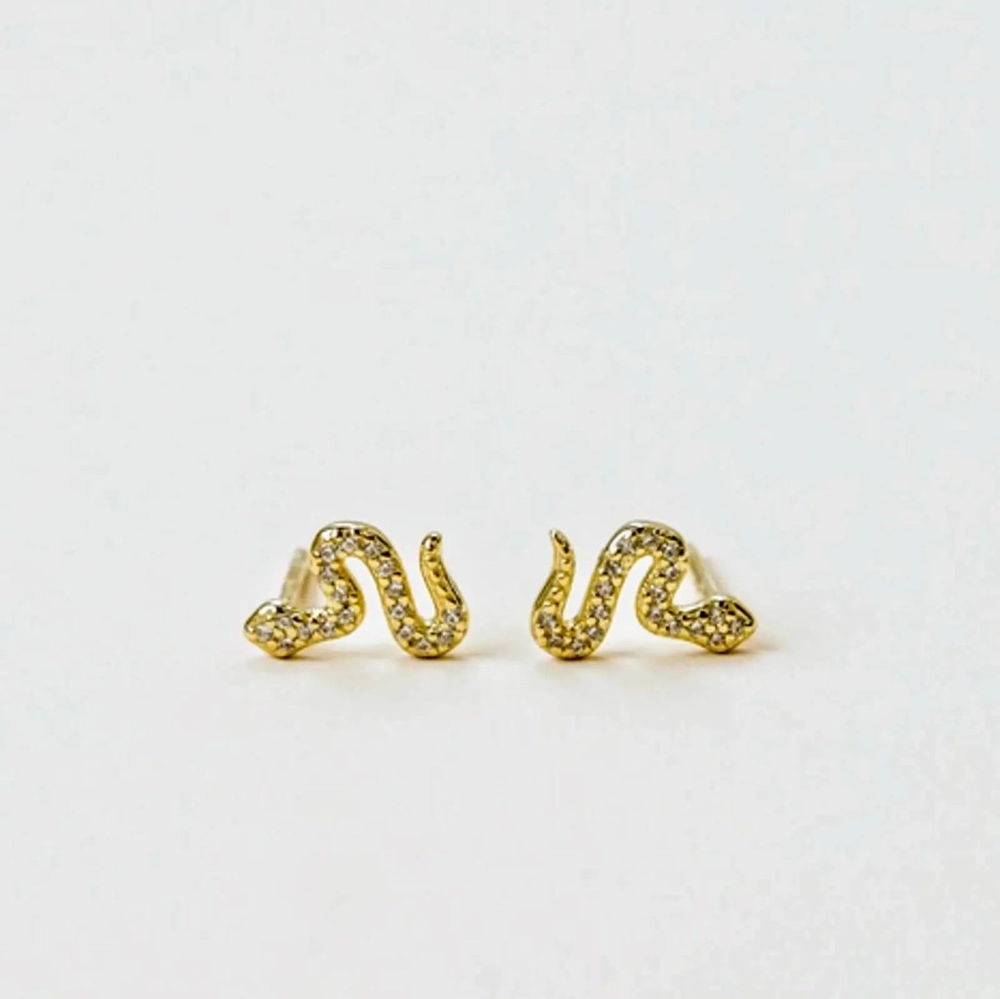 a pair of gold pave snake earrings