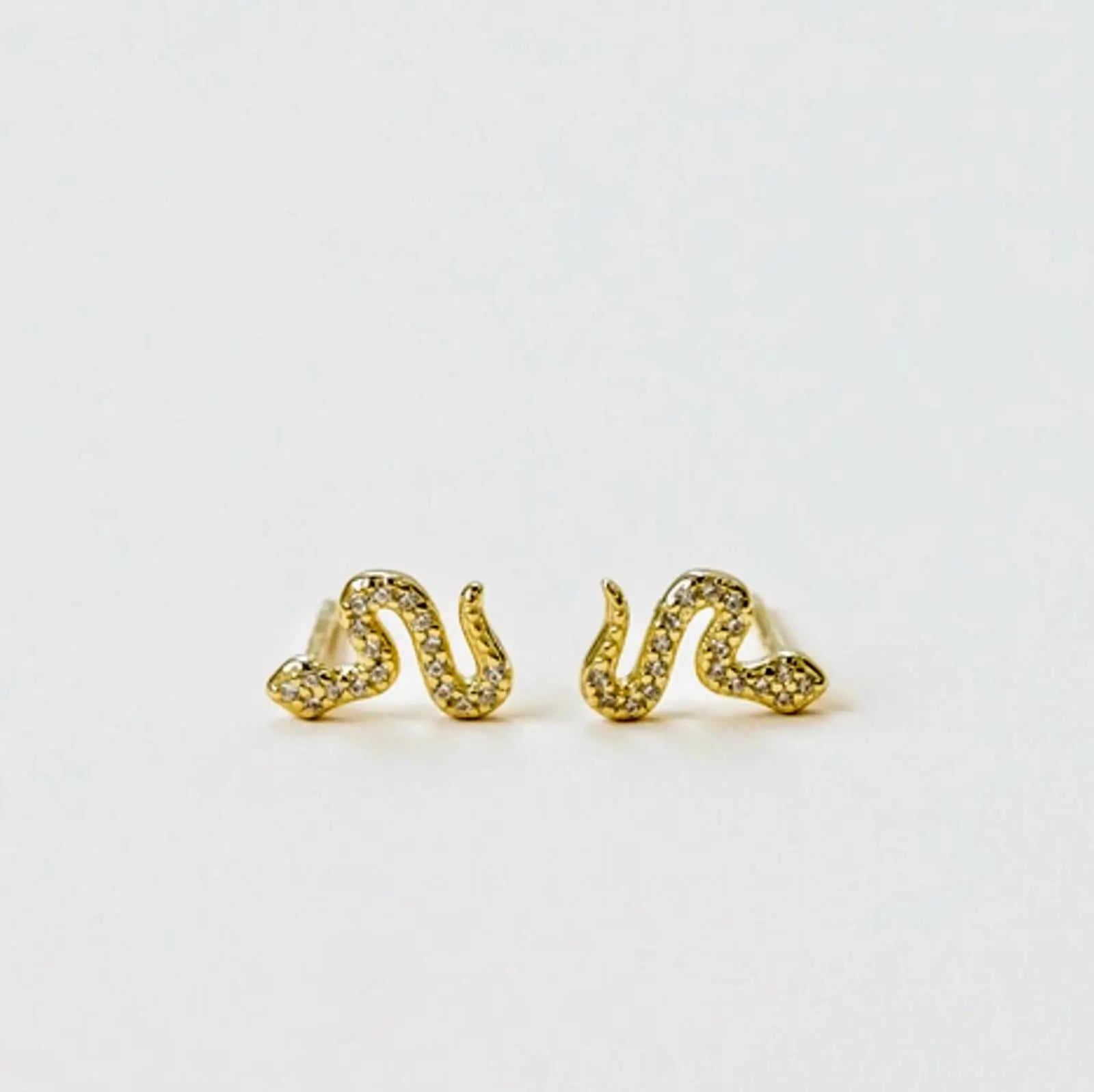 a pair of gold pave snake earrings