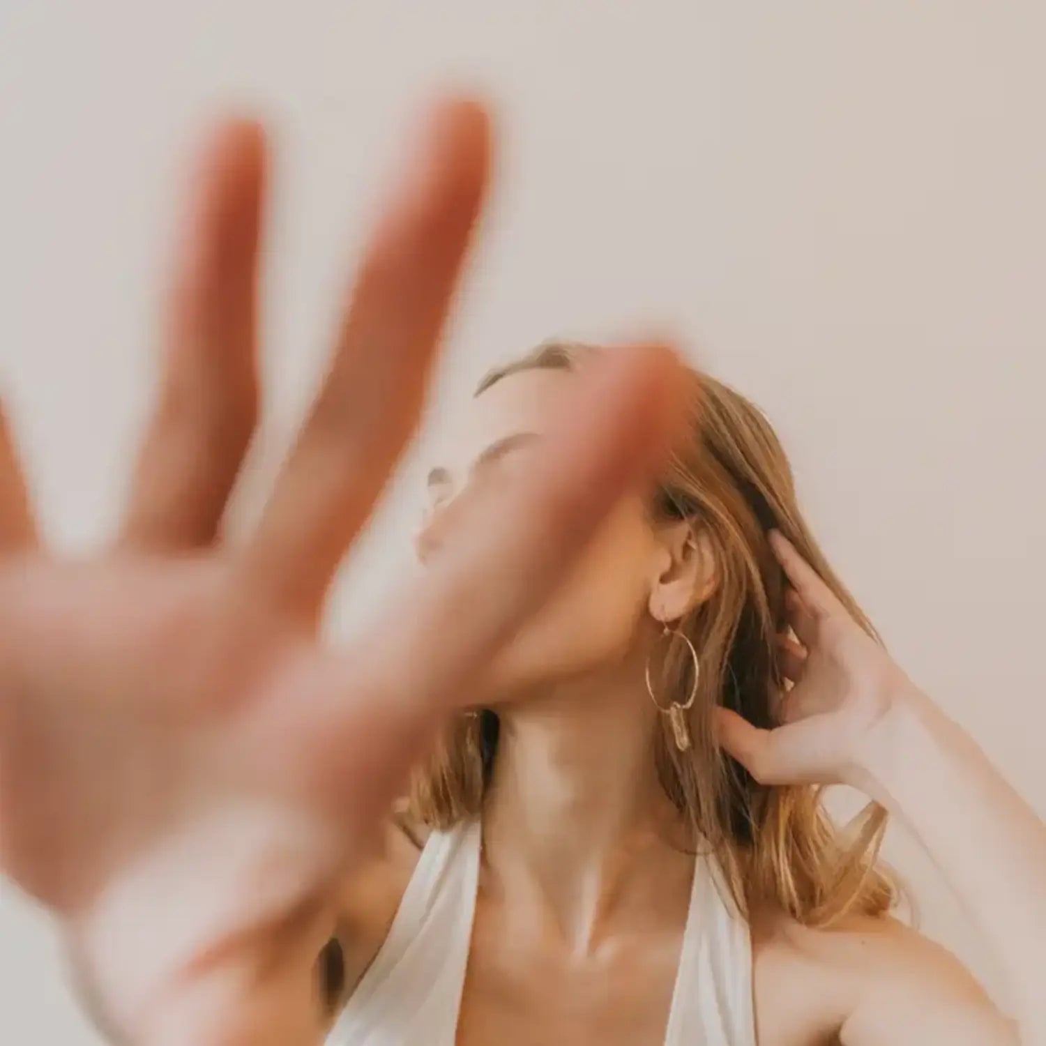 model with long blonde hair wearing gold boho hoop earrings with clear quartz stones