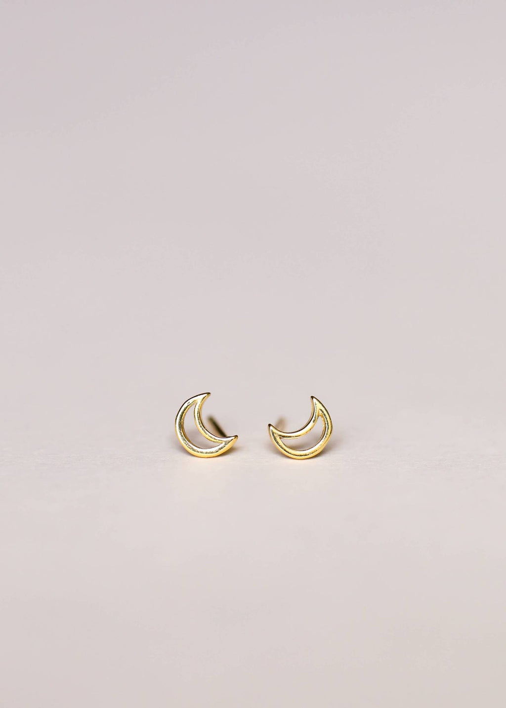 a pair of gold crescent moon earrings 