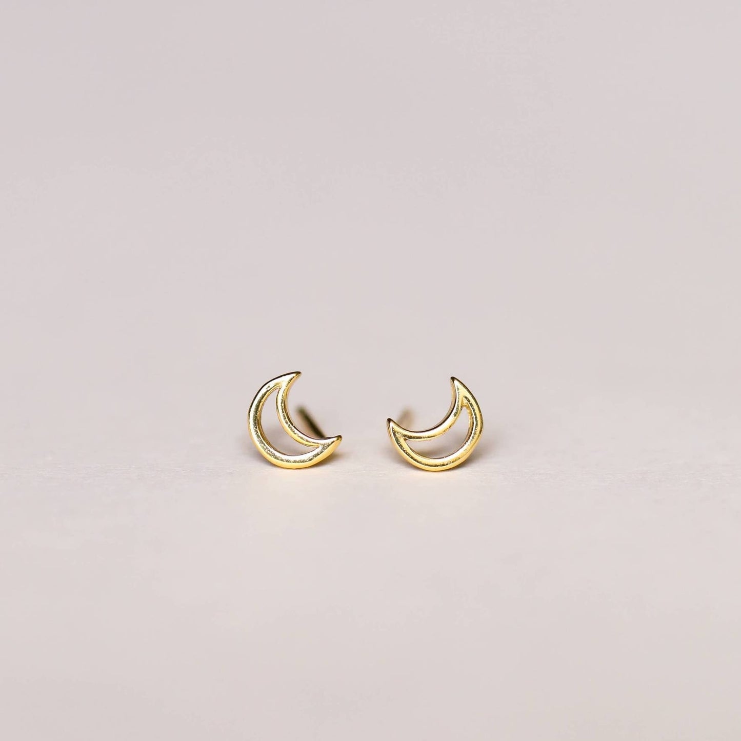 a pair of gold crescent moon earrings 