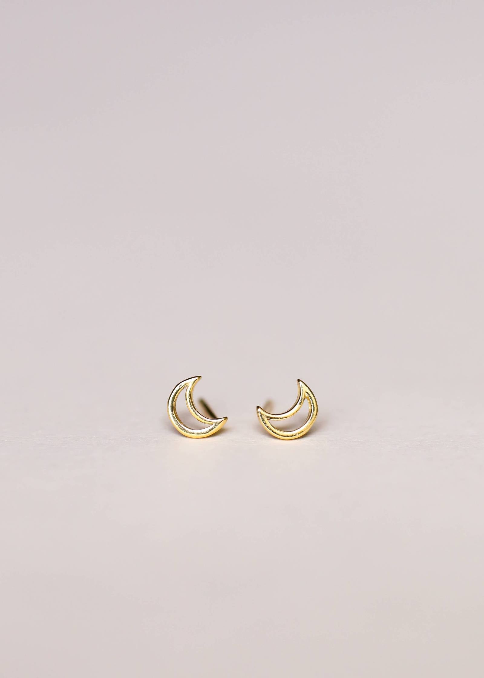 a pair of gold crescent moon earrings 