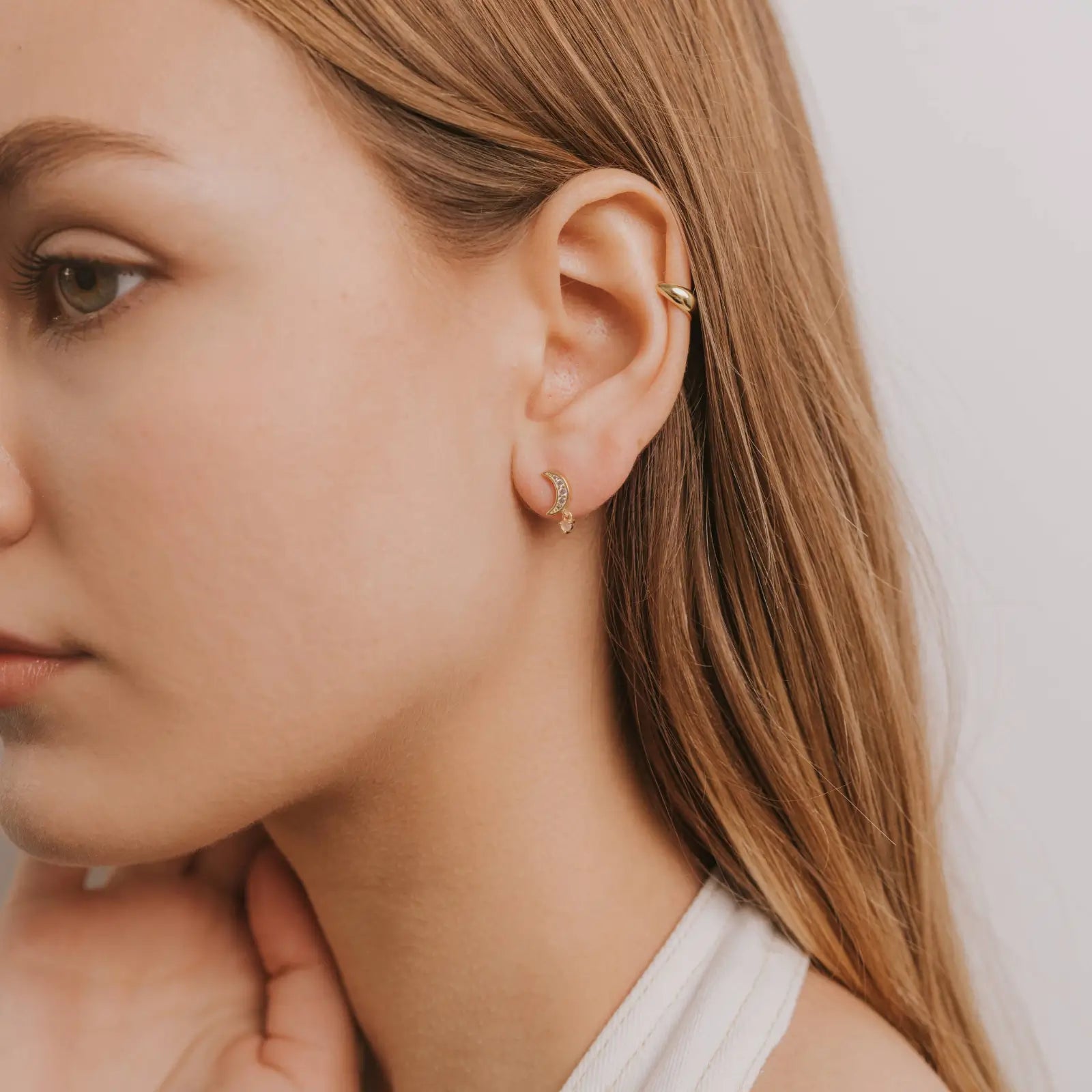 gold crescent moon gemstone drop earrings worn on a model