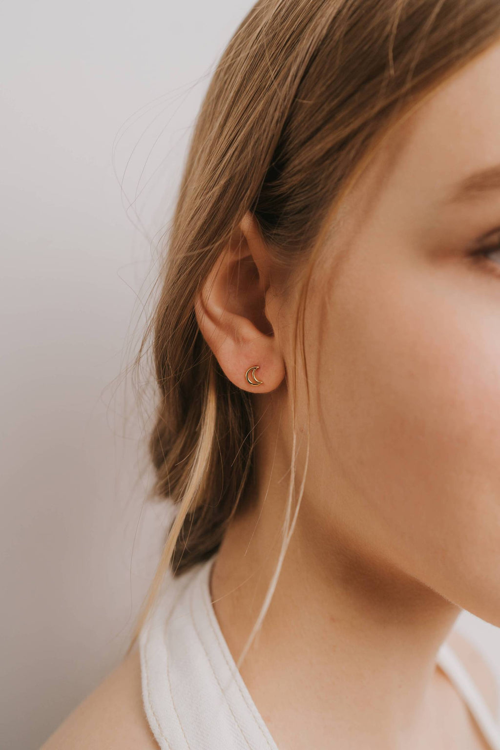 model wearing gold moon stud earrings 
