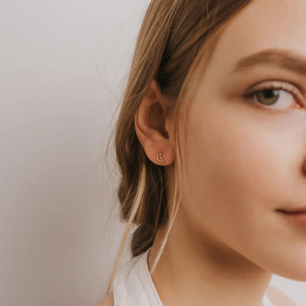 gold moon stud earrings shown on model