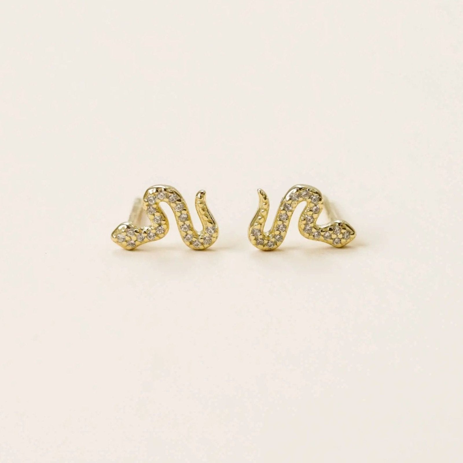 a pair of yellow gold snake earrings with simulated diamonds